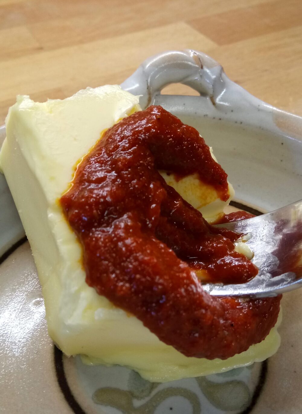 Gewürzbutter mit smoky joe. Ein Stück Butter, das mit Chilipaste vermischt wird.