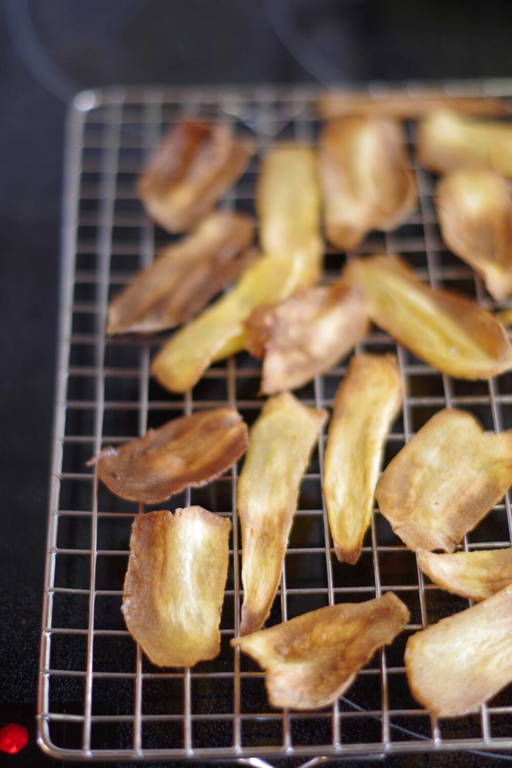 Pastinakenchips mit Chilipaste Knock out. Im Ofen getrocknete Scheiben auf einem Kuchengitter.