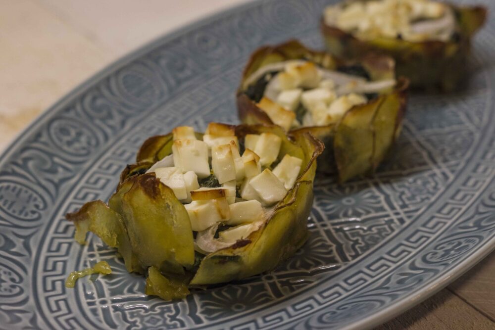 Mini-Spinatgratins aus einer Schale mit Kartoffelscheiben, gefüllt mit Spinat, Zwiebeln und obenauf gewürfelten Feta. Gebacken in einer Muffinform.