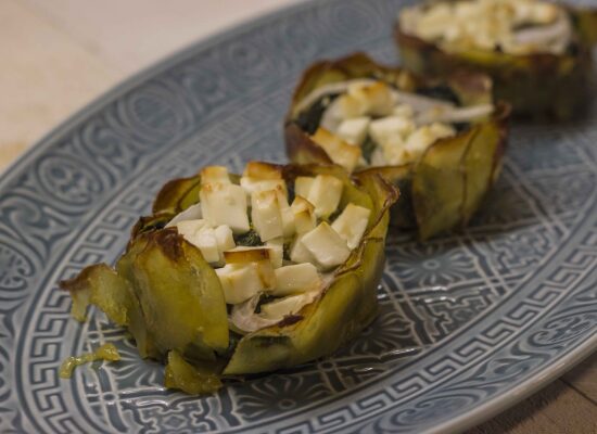 Mini-Spinatgratins aus einer Schale mit Kartoffelscheiben, gefüllt mit Spinat, Zwiebeln und obenauf gewürfelten Feta. Gebacken in einer Muffinform.