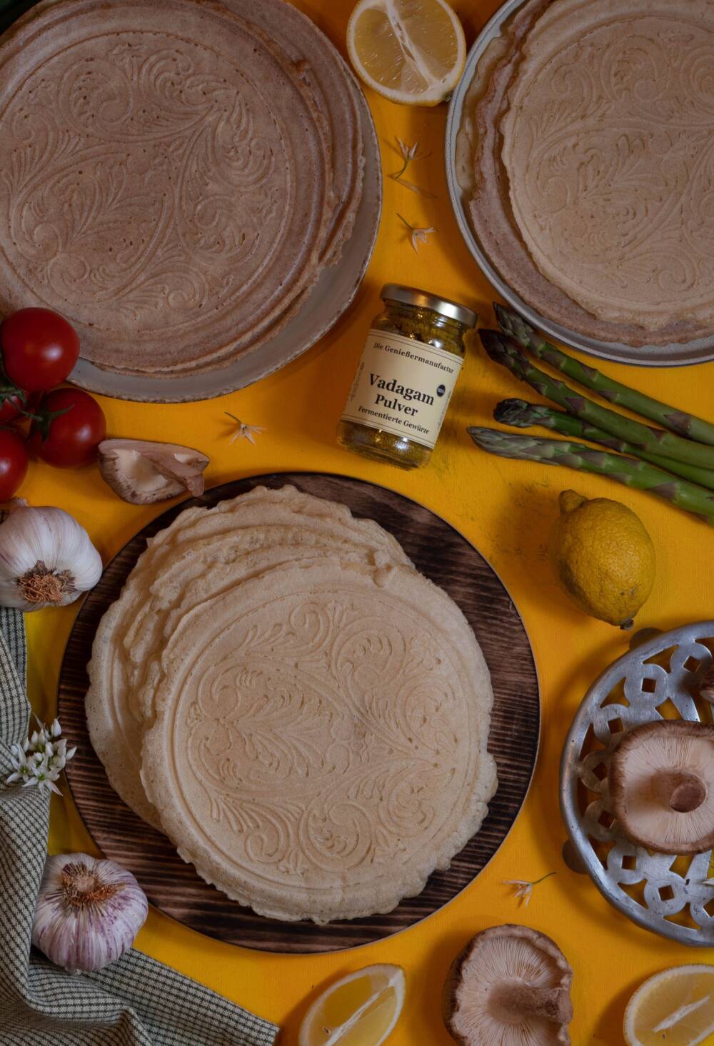 Tortillas aus dem Waffeleisen - am besten flach aus dem dänischen Waffeleisen. Angerichtet auf einem Holzbrettchen, daneben Gemüse für die Füllung.