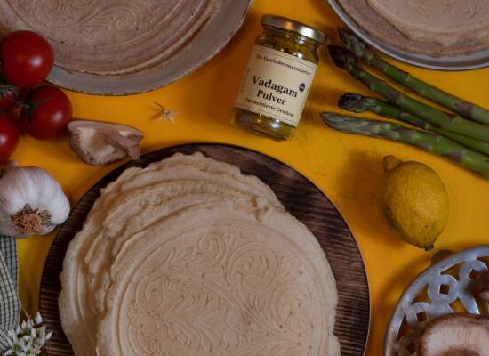 Tortillas aus dem Waffeleisen - am besten flach aus dem dänischen Waffeleisen. Angerichtet auf einem Holzbrettchen, daneben Gemüse für die Füllung.