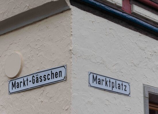 Mellrichstadt Hausecke mit Straßenschildern, Markt-Gässchen und Marktplatz.